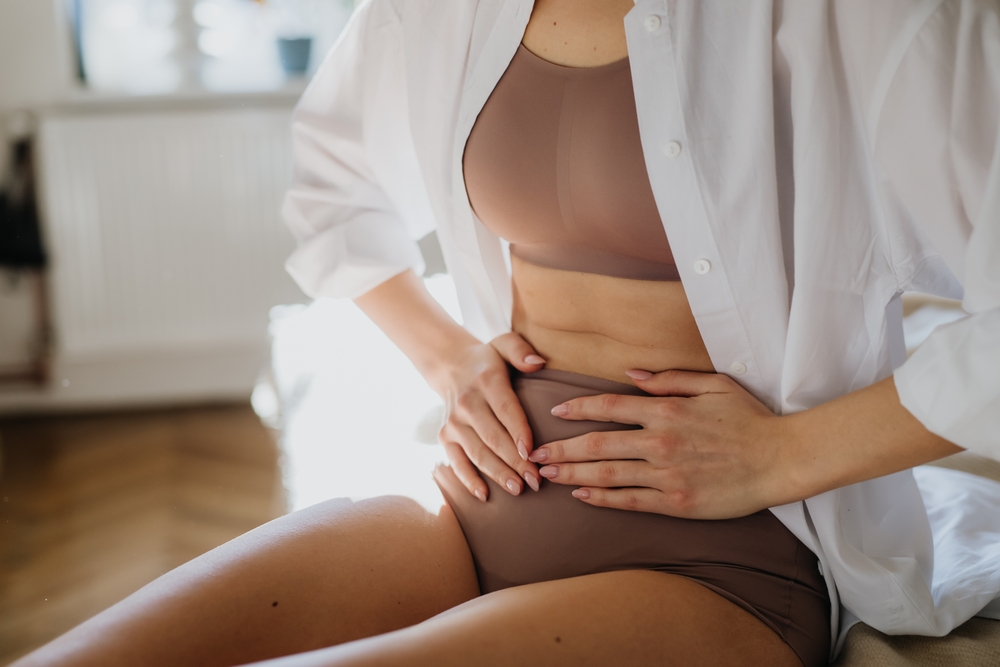 Woman at home suffering from menstrual pain.